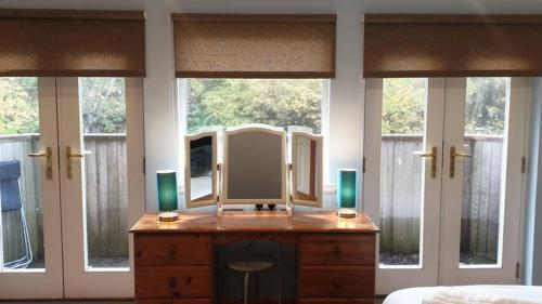a mirror on a dresser in a room with windows at Ensuite Rooms in Wick