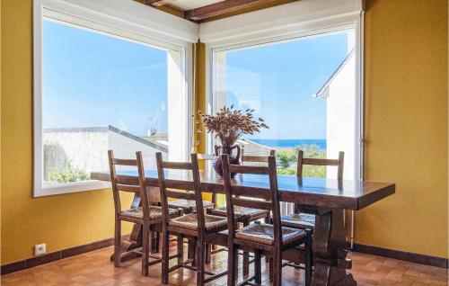 une salle à manger avec une table, des chaises et des fenêtres dans l'établissement Awesome Home In Trévou Treguignec, à Trélévern