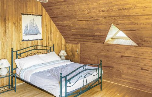 ein Schlafzimmer mit einem Bett in einem Zimmer mit Holzwänden in der Unterkunft Awesome Home In Trvou Treguignec With 4 Bedrooms And Wifi in Trélévern