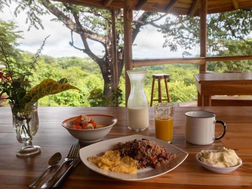 a table with a plate of food and a glass of milk at Finca Colibri Ecolodges en Pleine Nature ferry Playa Najanjo Costa Rica in Cabo Blanco