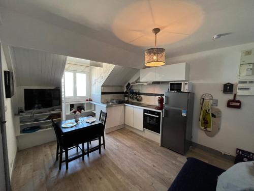Il comprend une cuisine équipée d'une table et d'un réfrigérateur. dans l'établissement Acrab, Appt vue mer au calme, à Luc-sur-Mer