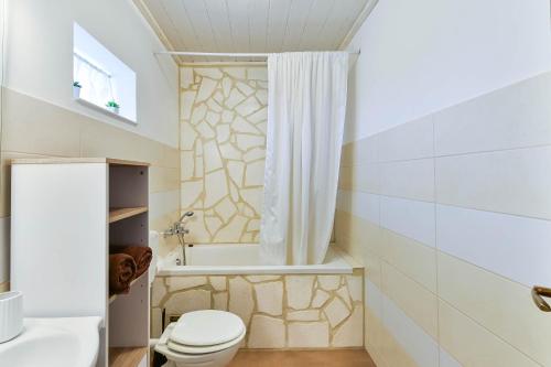 Un baño con inodoro, bañera y lavabo. en Villa MiA, en Sukošan