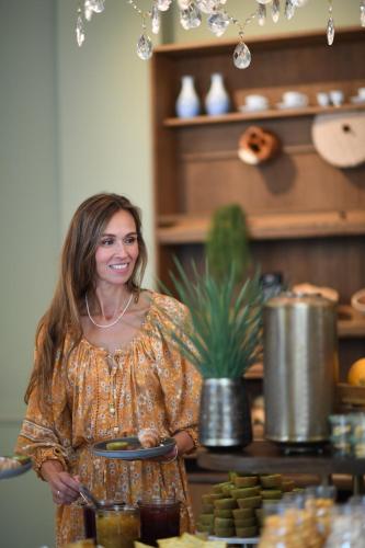 a woman standing in a kitchen holding a plate at Best Western Hotel Hebron in Copenhagen