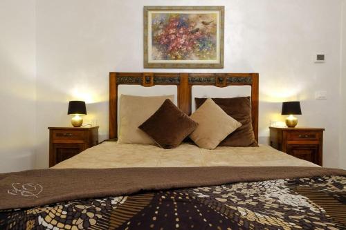 um quarto com uma cama com duas mesas de cabeceira e dois candeeiros em B&B Old Town San Marino em San Marino