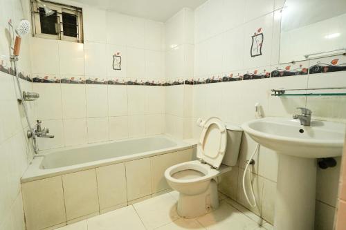a bathroom with a toilet and a sink and a bath tub at Gulshan Lovely 3-Bedroom Luxury Apartment in Dhaka
