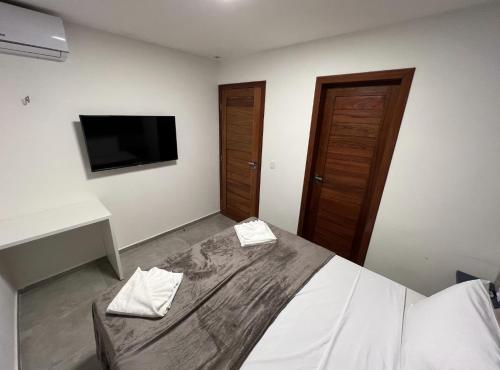 a bedroom with a bed and a flat screen tv at Fontes da Pipa by Liiv in Pipa