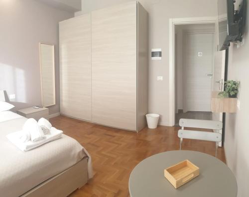 a white room with a bed and a table at B&B Dei Cardinali in Terni