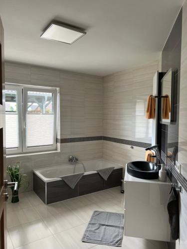 a large bathroom with a tub and a sink at Spreewälder Ferienhäuser am Berste - Ufer in Lübben