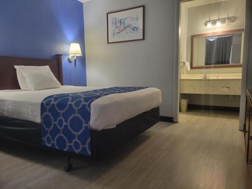 a hotel room with a bed and a bathroom at Baymont by Wyndham Hannibal in Hannibal