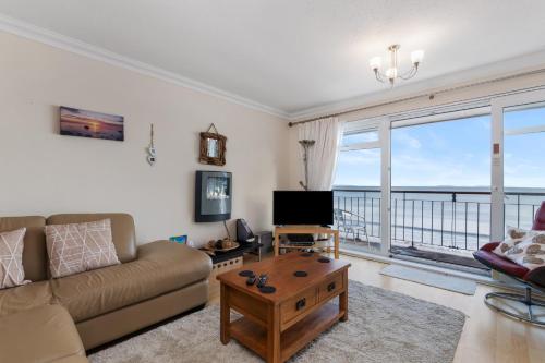 a living room with a couch and a coffee table at On The Beach - Direct Beach Access Sea Views in Saundersfoot