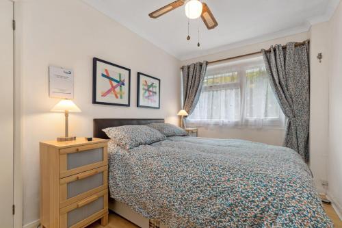 a bedroom with a bed and a dresser and a window at On The Beach - Direct Beach Access Sea Views in Saundersfoot