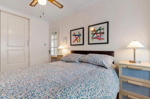 a bedroom with a bed and two pictures on the wall at On The Beach - Direct Beach Access Sea Views in Saundersfoot
