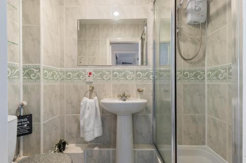 a bathroom with a sink and a shower at On The Beach - Direct Beach Access Sea Views in Saundersfoot