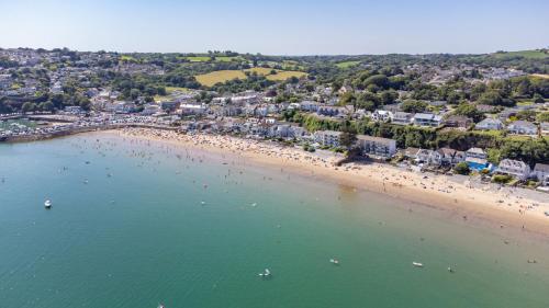 an aerial view of a beach with people in the water at On The Beach - Direct Beach Access Sea Views in Saundersfoot