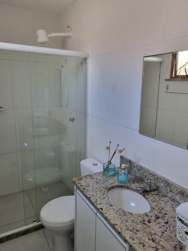 a bathroom with a sink and a toilet and a mirror at Riverside imbassai bloco B003 in Mata de Sao Joao