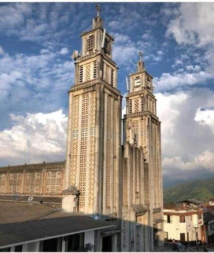 un gran edificio con dos torres con relojes. en A su Merced entre Nubes, Montañas y Café., en La Merced