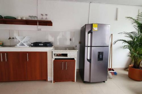 a kitchen with a stainless steel refrigerator and a stove at A su Merced entre Nubes, Montañas y Café. in La Merced