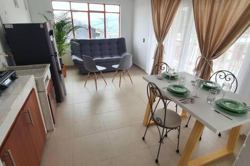 a kitchen and living room with a table and a couch at A su Merced entre Nubes, Montañas y Café. in La Merced