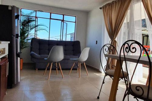 sala de estar con sofá azul y sillas en A su Merced entre Nubes, Montañas y Café., en La Merced