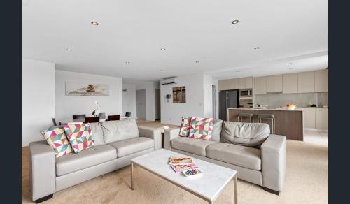 a living room with two couches and a table at Azzura Greens Resort in Gold Coast