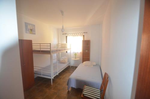 a small bedroom with a bunk bed and a desk at The Occidental House in Tamaduste