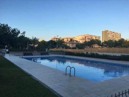 a swimming pool in a park with buildings in the background at Stylish & cosy 3 bed apartment! in Benicàssim