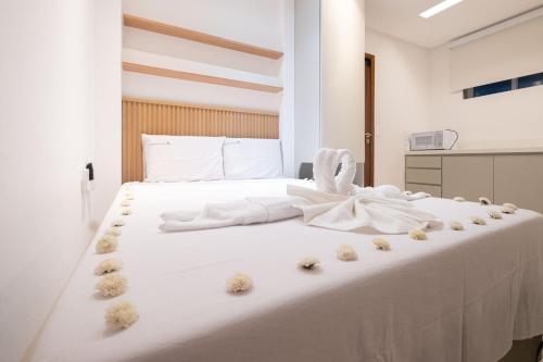 un letto bianco con alcuni animali di peluche sopra di Pé na Vila a Porto De Galinhas