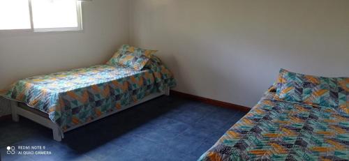 a bedroom with a bed and a bed and a chair at Chalet de 2 dorm- 1baño - Piscina in Valeria del Mar