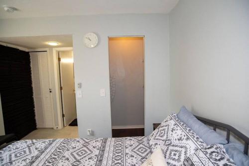 a bedroom with a bed and a clock on the wall at Cozy Studio Apartment close to Disney in Davenport