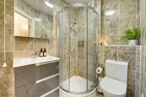 a bathroom with a shower and a toilet and a sink at City Centre, 2 Bedroom, Secured Parking, 3 King Bed, WiFi Sleep 6 Guest Comfortable on Three King Size Beds, Jewellery Quarter , Birmingham City Centre , Allocated Secured Parking in Birmingham
