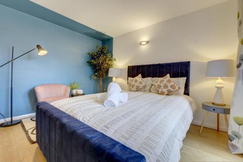 a bedroom with a large bed with a blue wall at City Centre, 2 Bedroom, Secured Parking, 3 King Bed, WiFi Sleep 6 Guest Comfortable on Three King Size Beds, Jewellery Quarter , Birmingham City Centre , Allocated Secured Parking in Birmingham