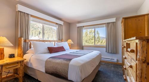 um quarto com uma cama grande e 2 janelas em Red Wolf Lodge at Olympic Valley em Olympic Valley
