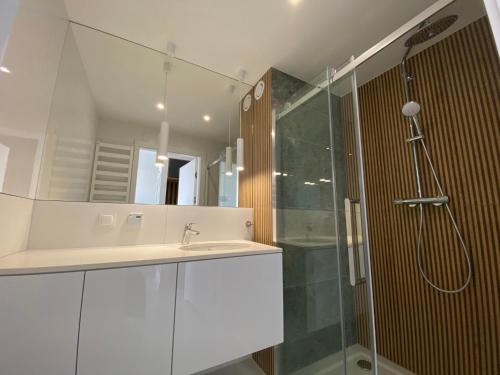 bagno con lavandino, doccia e specchio di MIZU Apartamenty - Westin a Kołobrzeg
