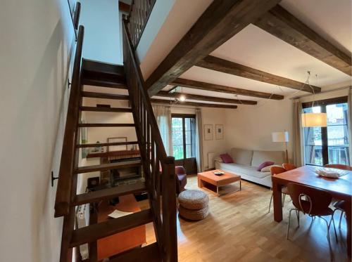 a living room with a spiral staircase and a table at CHECK-IN CASAS Casa Plaza Mayor in Villanova