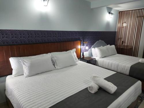 a hotel room with two beds with towels on them at Añoranza Hotel Boutique in Ciudad Hidalgo