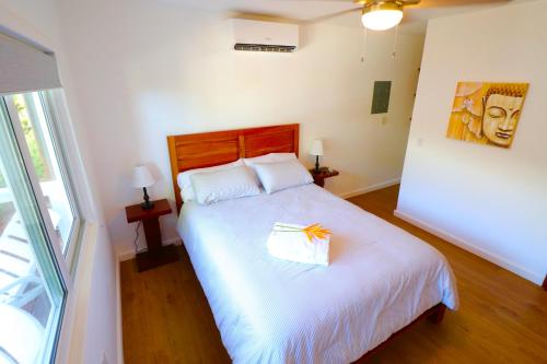 a bedroom with a white bed with a gift on it at New One Bedroom Suite West Bay Roatan - Number 6 in West Bay