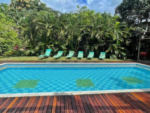 a swimming pool with chairs on a wooden deck at La Casablanca Tayrona House in Calabazo