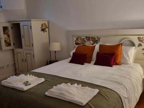 a bedroom with a large bed with two towels on it at Casa de Diana in Évora