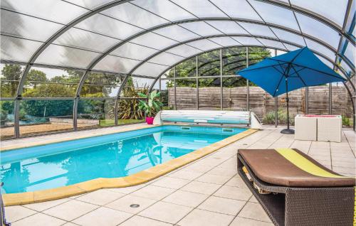 - une piscine avec un parasol dans une serre dans l'établissement Stunning Home In Pommeret With Sauna, à Pommeret