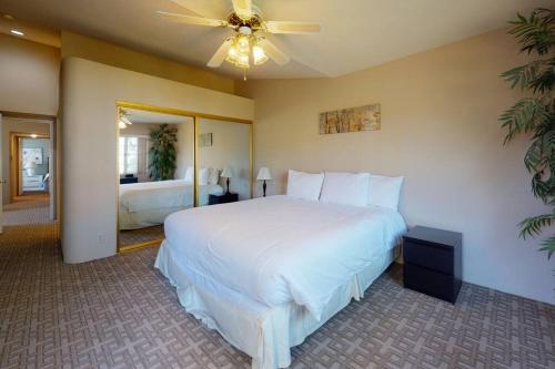 a bedroom with a large white bed with a ceiling fan at DF202 Airy 2 Bedroom Condo Overlooking the Pool in Palm Desert