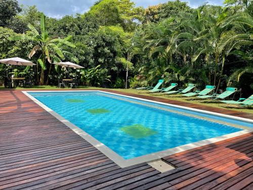 a swimming pool with chairs and a wooden deck at Hotel La Casablanca Tayrona in Calabazo