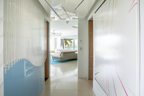 a hallway with white walls and a couch in a room at Netanya Noosa Beachfront Resort in Noosa Heads