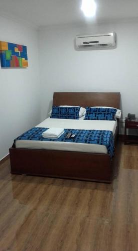 a bed in a room with a wooden floor at Hotel Kamani Florencia in Florencia