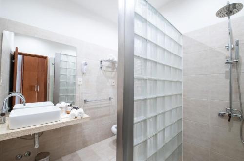 uma casa de banho com um lavatório e um chuveiro em Bemar Carmelo Hotel em Carmelo