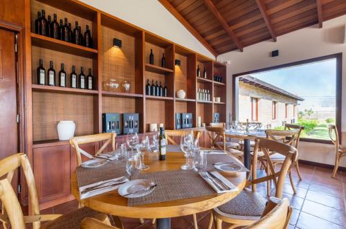 a dining room with a table and some wine bottles at Bemar Carmelo Hotel in Carmelo