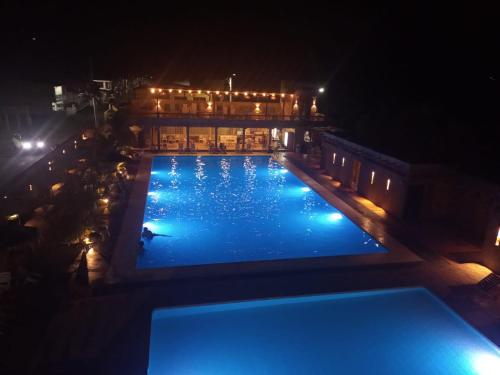una piscina por la noche con gente nadando en ella en la casita del arbol guaduas cundi. en Guaduas