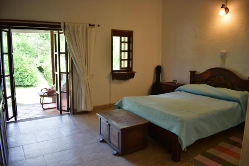 a bedroom with a bed and a door to a patio at Finca Milandia in Villeta