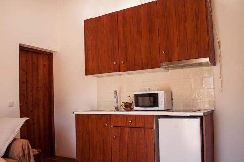 cocina con armarios de madera y microondas blanco en Horta das Laranjas en Serpa