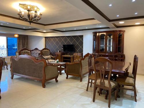 sala de estar con sofá, mesa y sillas en شقه مطله علي قناة السويس والبحر فيو رائع 702 بورسعيد en Port Said