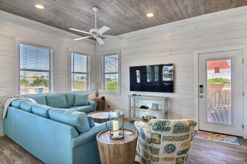 Una sala de estar con un sofá azul y un televisor. en The Beach Buoy, en Port Aransas